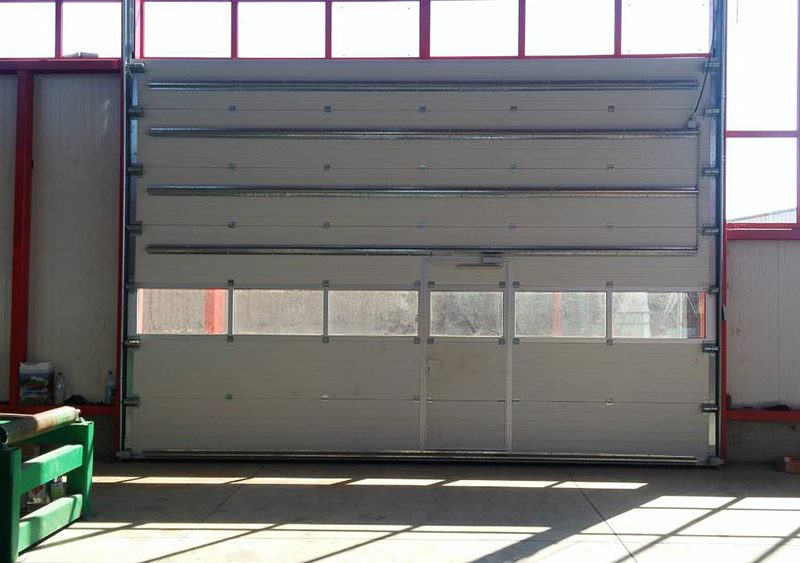Стара Загора - Индустриална секционна врата с един остъклен панел и вградена проходна врата. Задвижване с редуктор 003