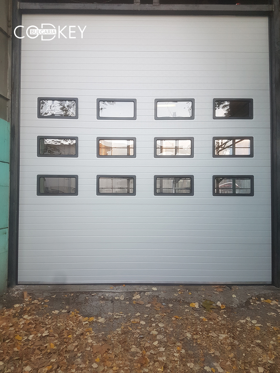 Индустриална секционна врата в град Русе с три реда остъклени с декоративни прозорци панели_002