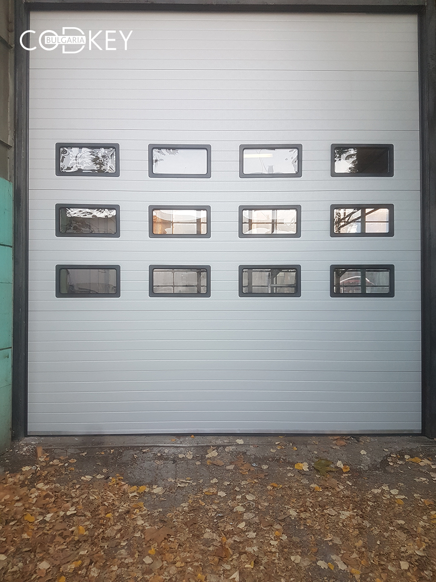 Индустриална секционна врата в град Русе с три реда остъклени с декоративни прозорци панели_003
