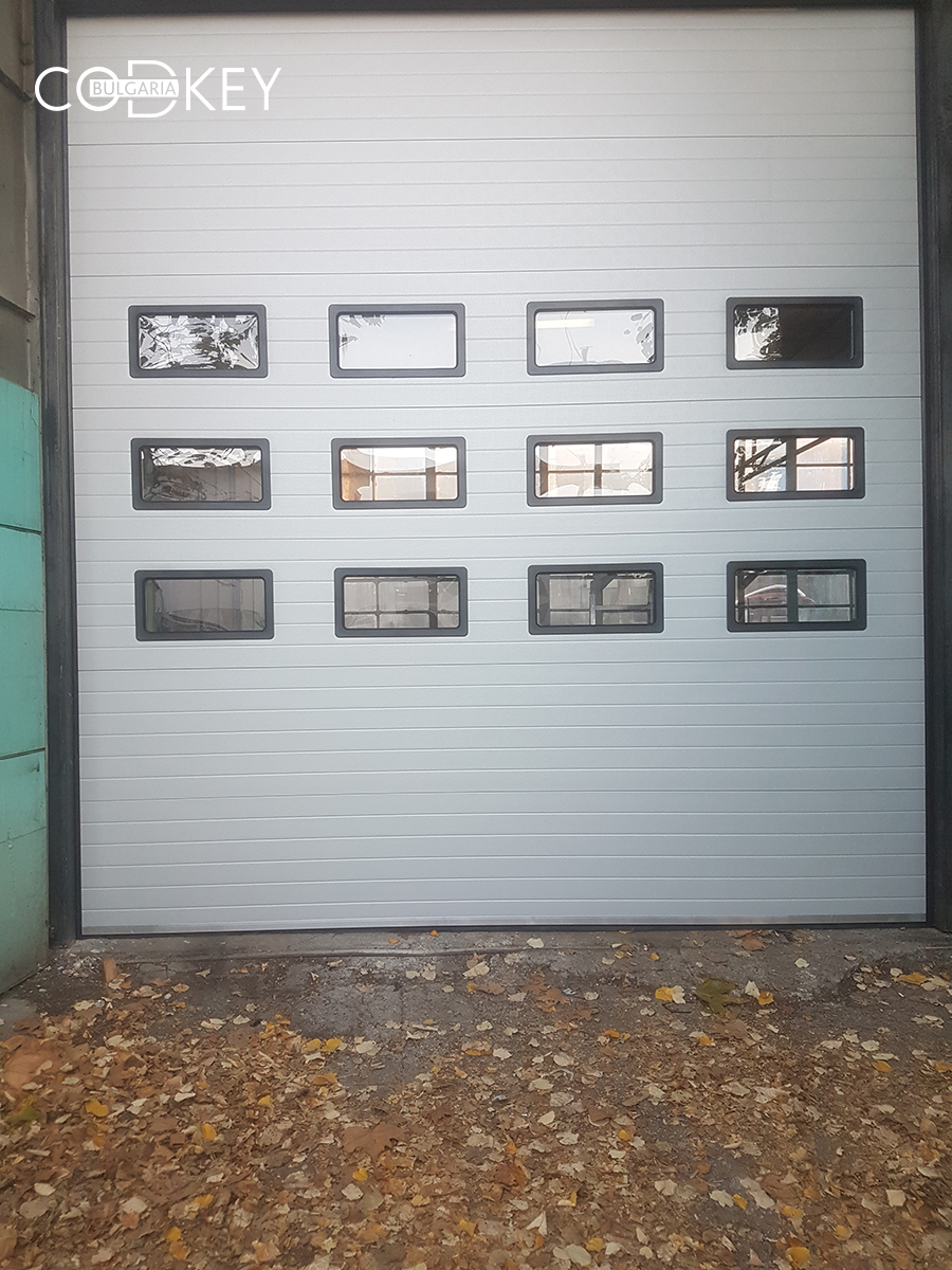 Индустриална секционна врата в град Русе с три реда остъклени с декоративни прозорци панели_004